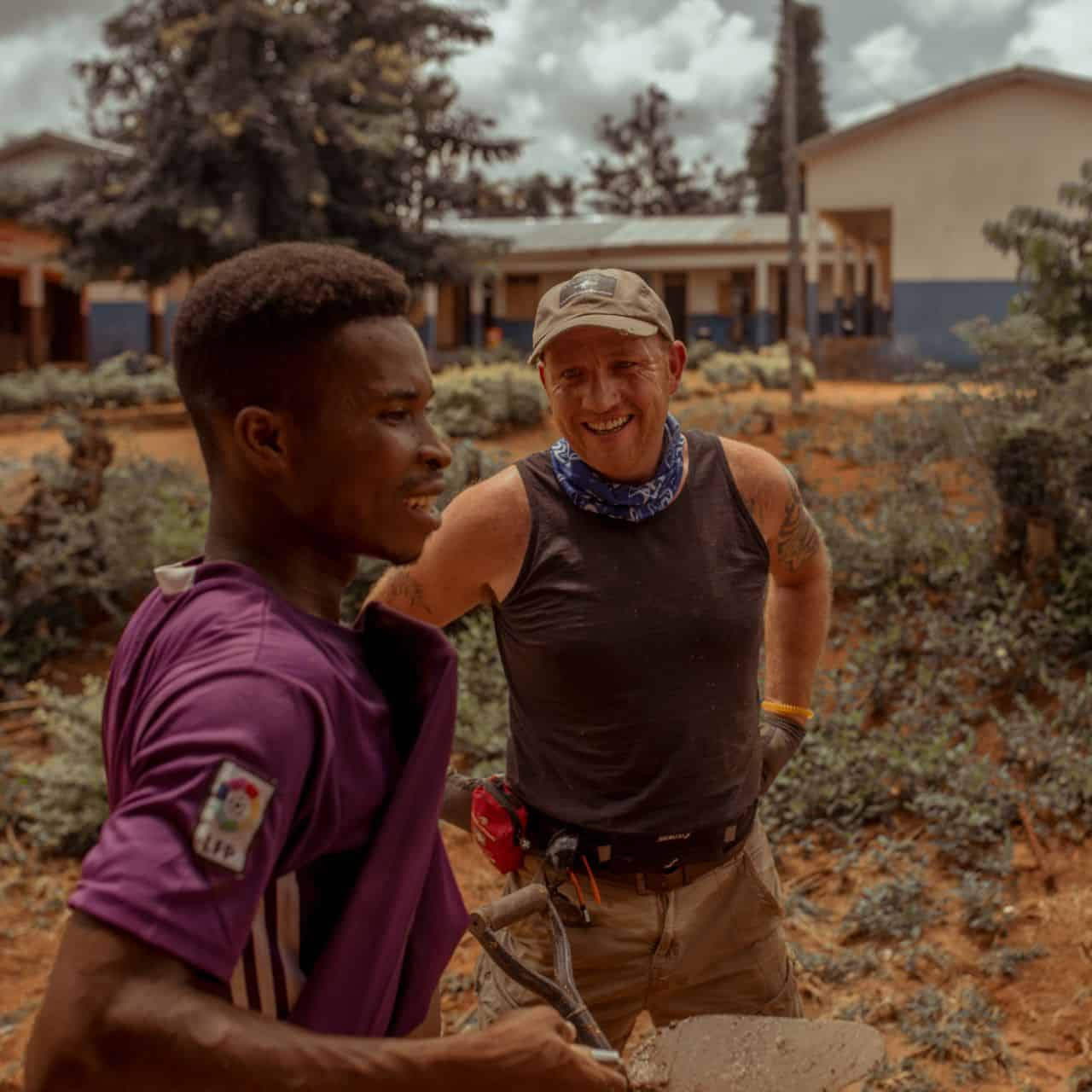 volunteer talking to team member on building project in west Africa